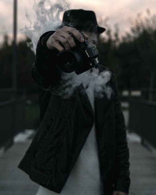 Person holding Panasonic Lumix GH5S camera smoking