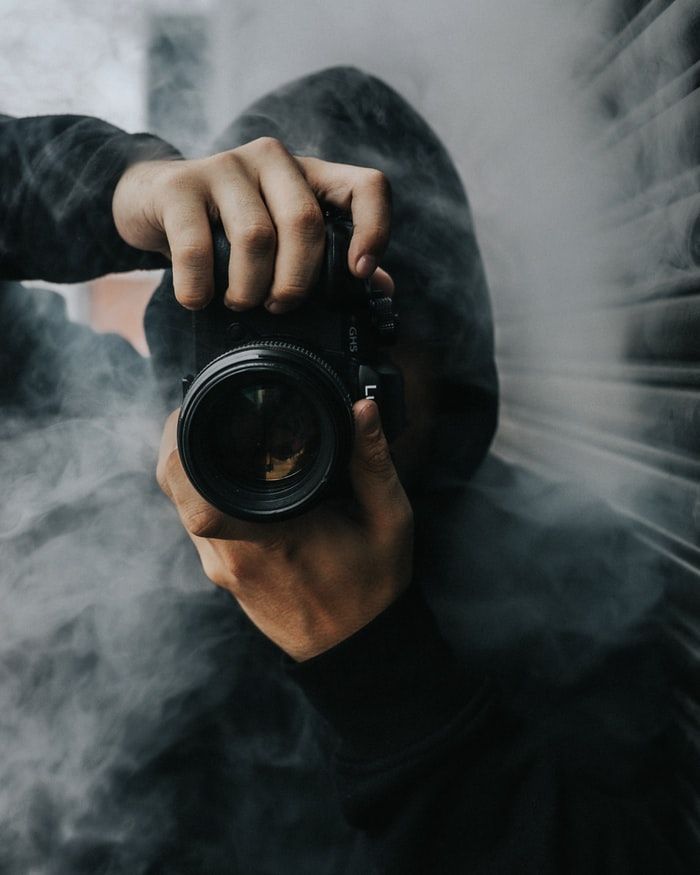 Photographer holding Panasonic Lumix GH5S camera in smoke