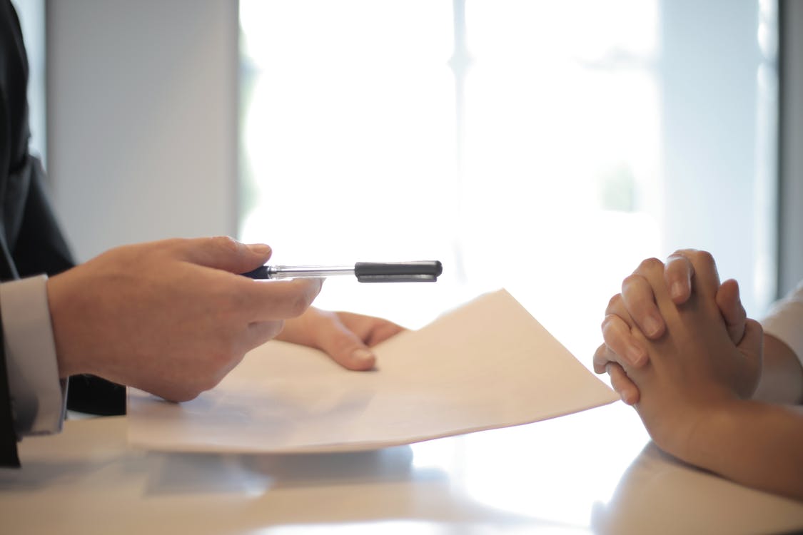 signing a leasing contract pen and paper in hand