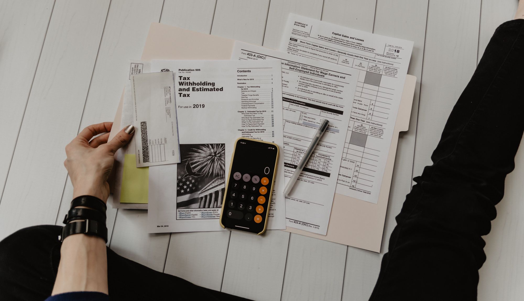 person-holding-financial-papers-and-calculator