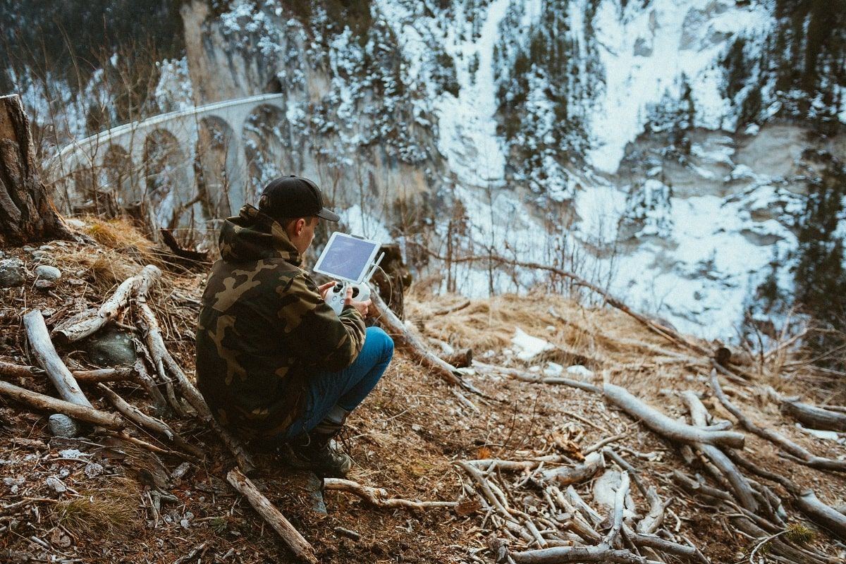 man flying drone with tablet