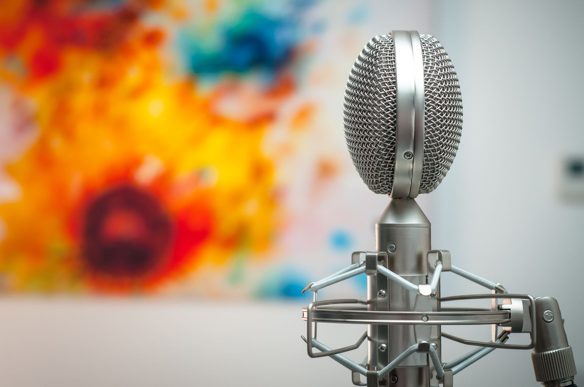 A microphone with a colorful painting on the background